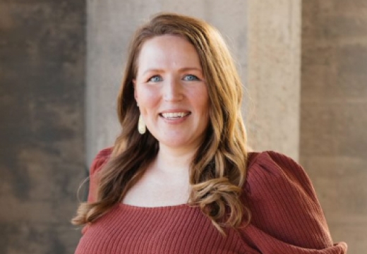 Jessica Jarmin smiling into at camera with an industrial background